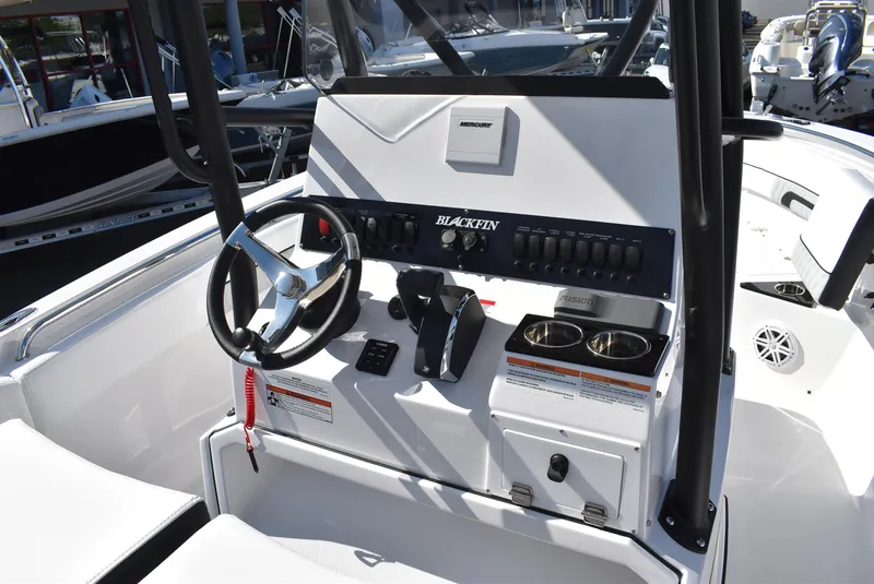 Slide: The Image of 2025 Blackfin 222CC boat console with steering wheel, controls, and cup holders. - 11