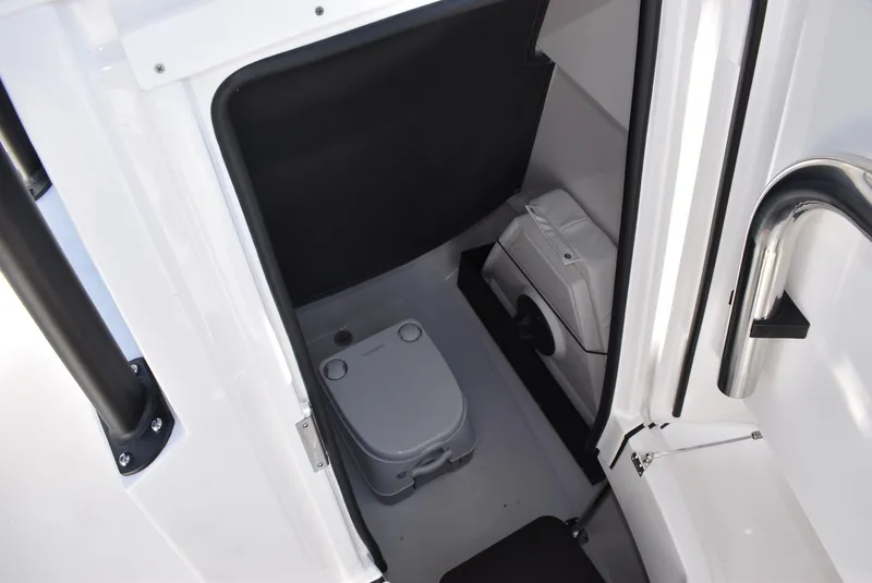 Slide: The Image of 2025 Blackfin 222CC boat interior with compact marine toilet and storage area. - 18