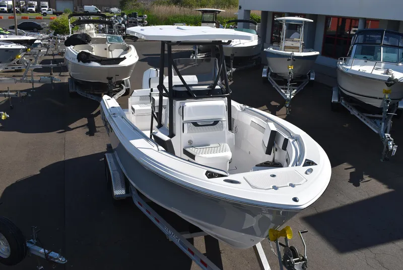 Slide: The Image of 2025 Blackfin 222CC boat on trailer, displayed outdoors among other boats. - 3