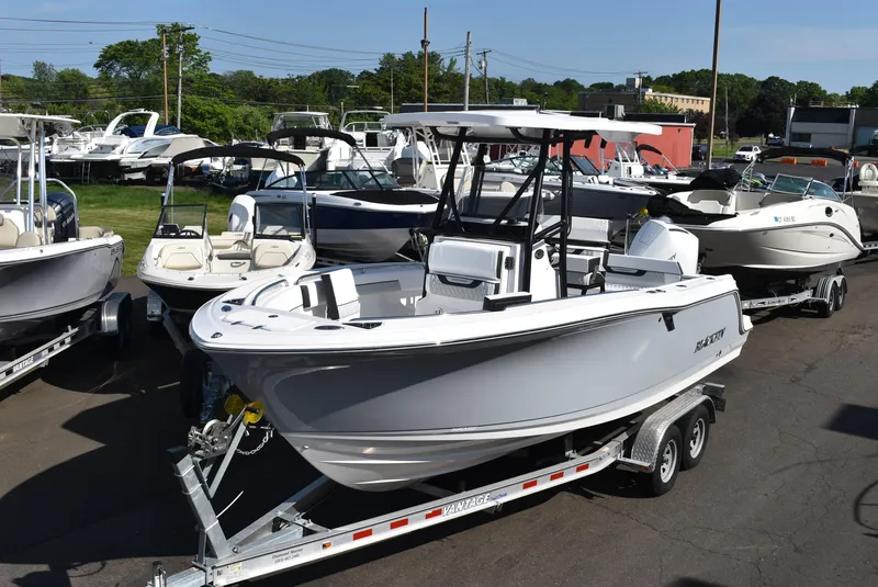 Slide: The Image of 2025 Blackfin 222CC boat on trailer, surrounded by other boats in a dealership lot. - 4