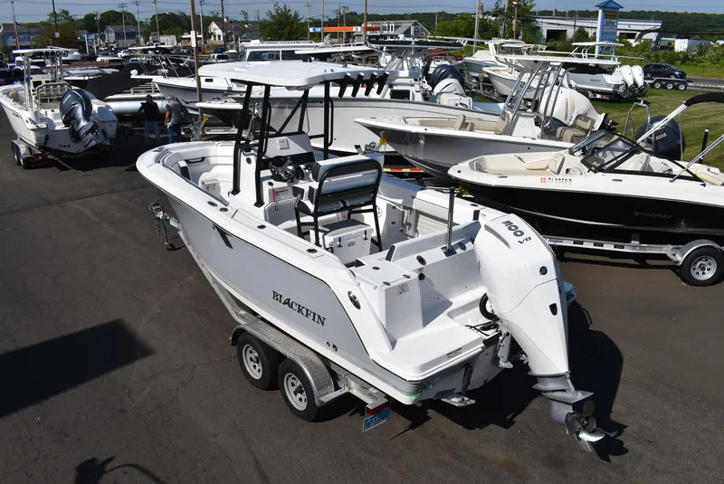 Slide: The Image of 2025 Blackfin 222CC boat on trailer in a marina with other boats. - 5