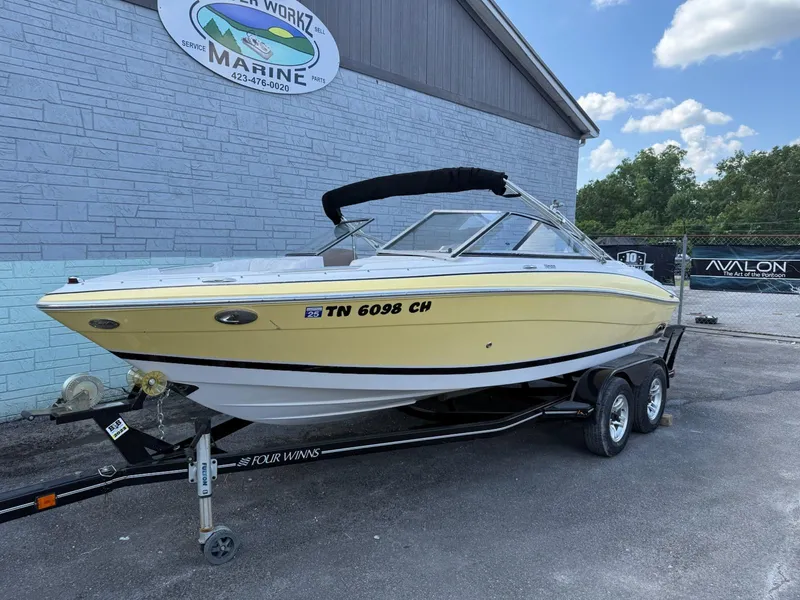 The Image of 2009 Four Winns H200 boat on trailer, parked outside a marine service center. - 0