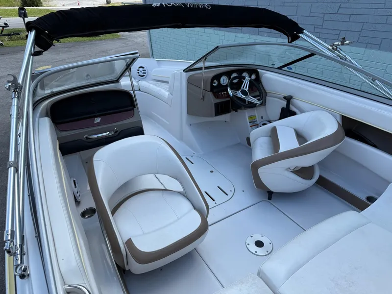 Slide: The Image of 2009 Four Winns H200 boat interior with white and beige seating, steering wheel, and dashboard. - 4
