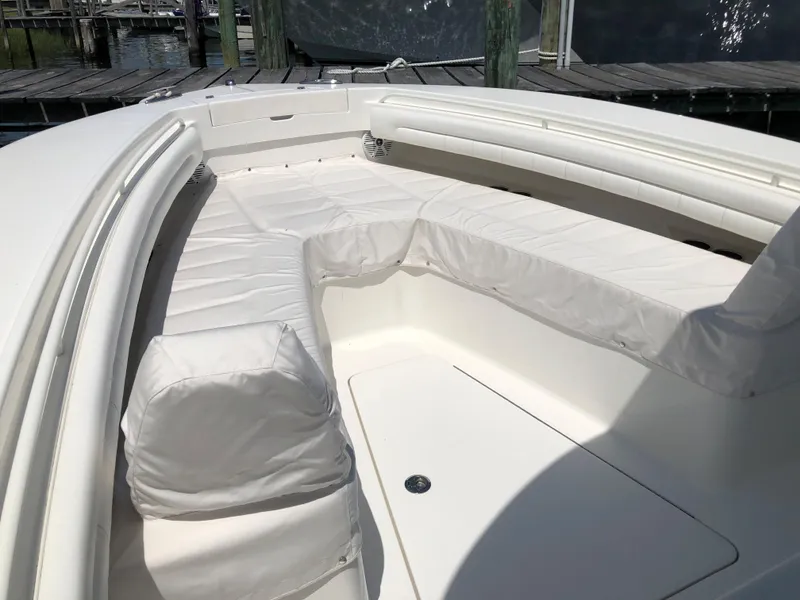 Slide: The Image of 2018 Regulator 28 Center Console boat with white cushioned seating area. - 13