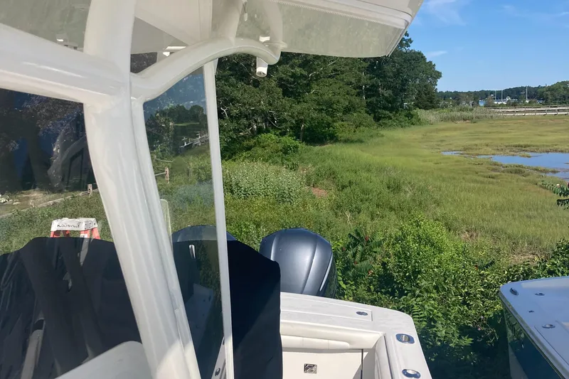 Slide: The Image of 2018 Regulator 28 Center Console boat with Optimus 360 Joystick, near lush greenery. - 22