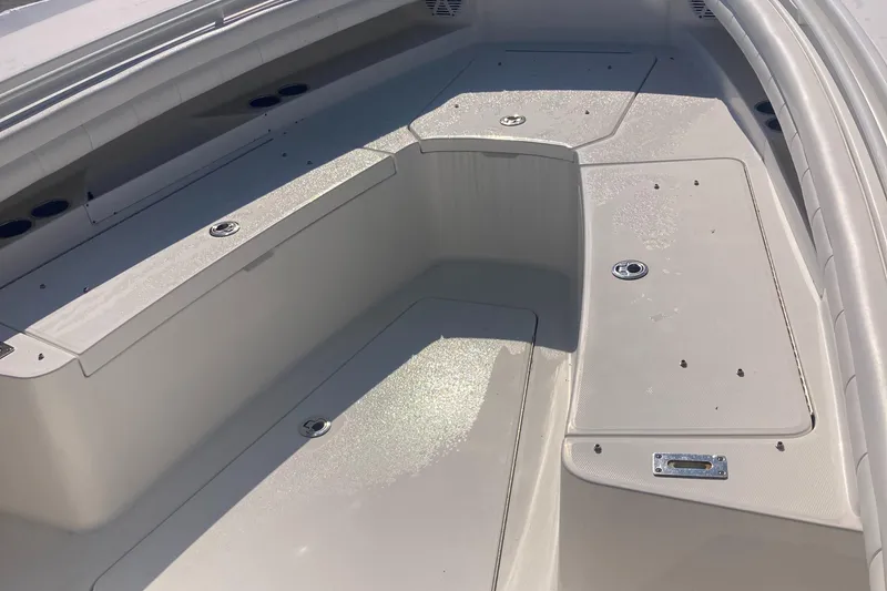Slide: The Image of 2018 Regulator 28 Center Console boat deck with storage compartments and seating area. - 26