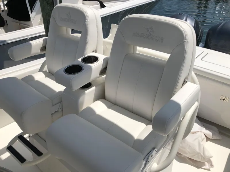Slide: The Image of 2018 Regulator 28 Center Console boat seats with cup holders, featuring Optimus 360 Joystick Control. - 7
