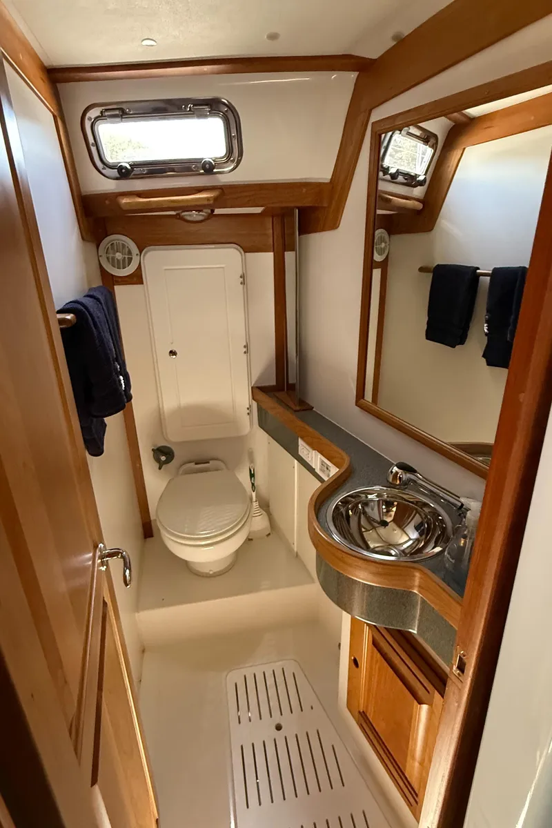 Slide: The Image of 2024 Tartan 455 yacht bathroom with modern fixtures and wooden accents. - 17