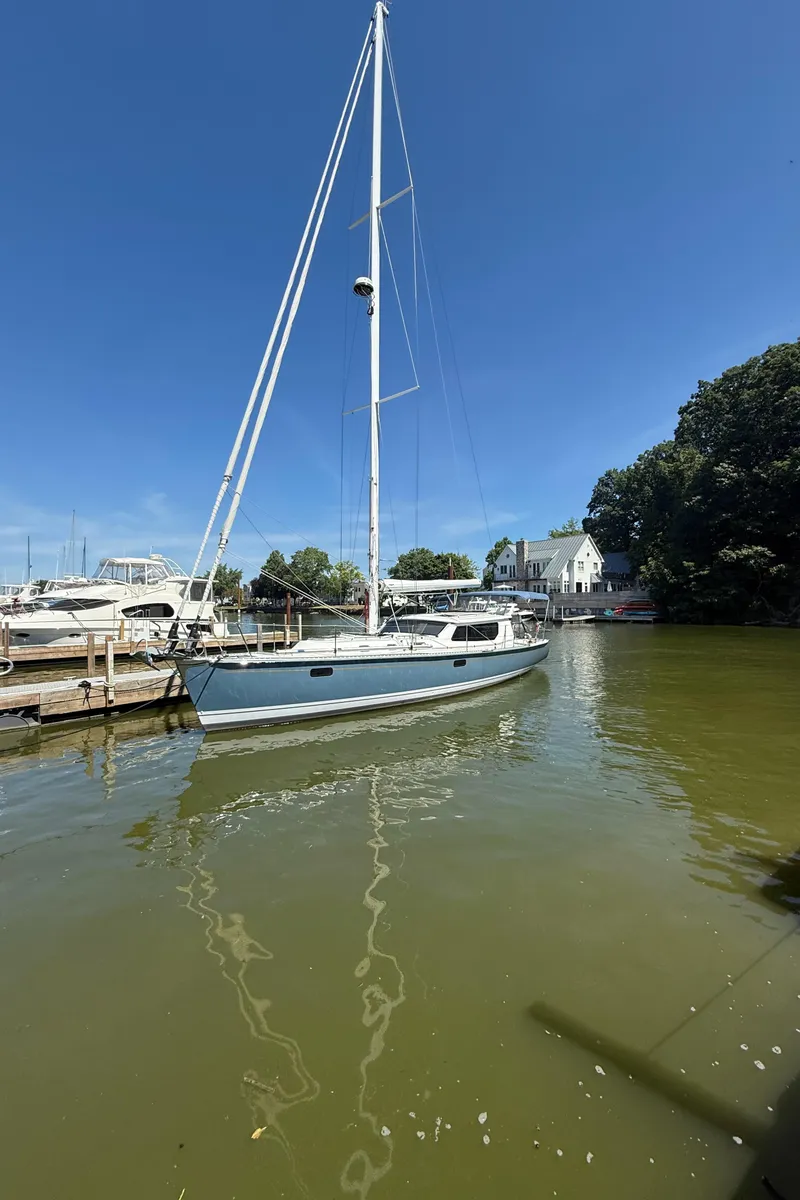 Slide: The Image of Sailboat Tartan 455, 2024 model, docked in a serene marina under clear blue skies. - 22
