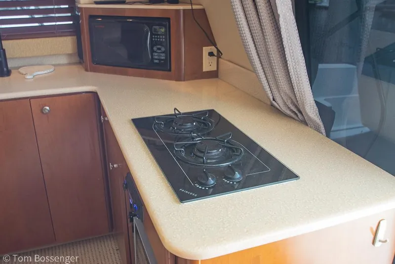 Slide: The Image of 2005 Meridian 341 Sedan kitchen with stove, microwave, and wooden cabinetry. - 16