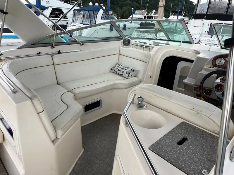 Slide: The Image of 2004 Rinker Fiesta Vee 270 boat interior with seating and helm, docked at marina. - 3