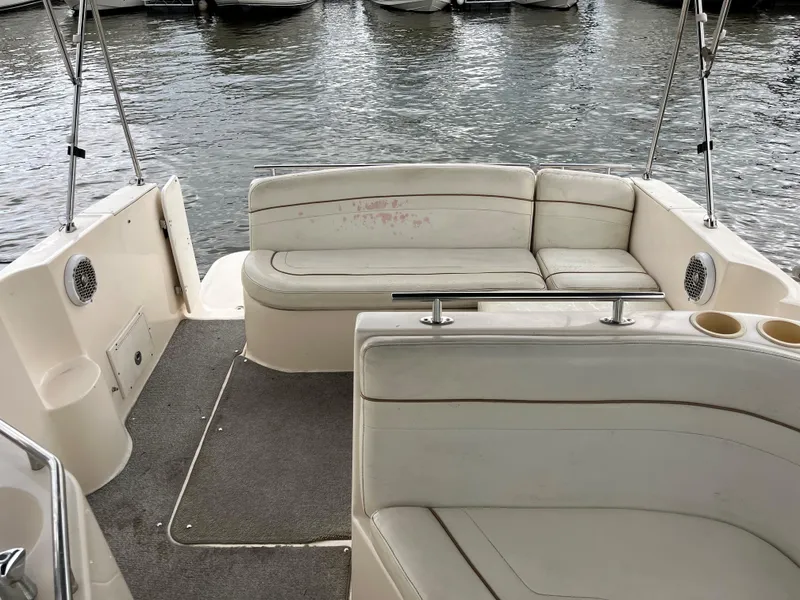 Slide: The Image of 2004 Rinker Fiesta Vee 270 boat interior with white seating and carpeted floor. - 4