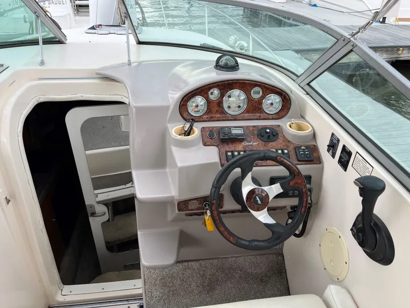 Slide: The Image of 2004 Rinker Fiesta Vee 270 boat cockpit with steering wheel and control panel. - 6