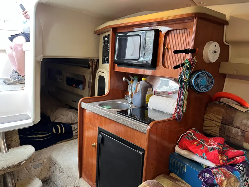 Slide: The Image of 2004 Rinker Fiesta Vee 270 cabin interior with kitchenette and cozy sleeping area. - 7