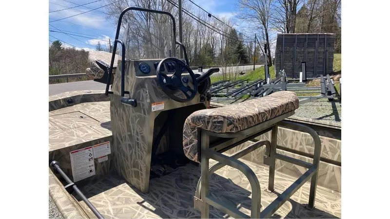 Slide: The Image of 2025 Lowe Roughneck RX1760 Pathfinder boat with camouflage seating and steering console. - 7