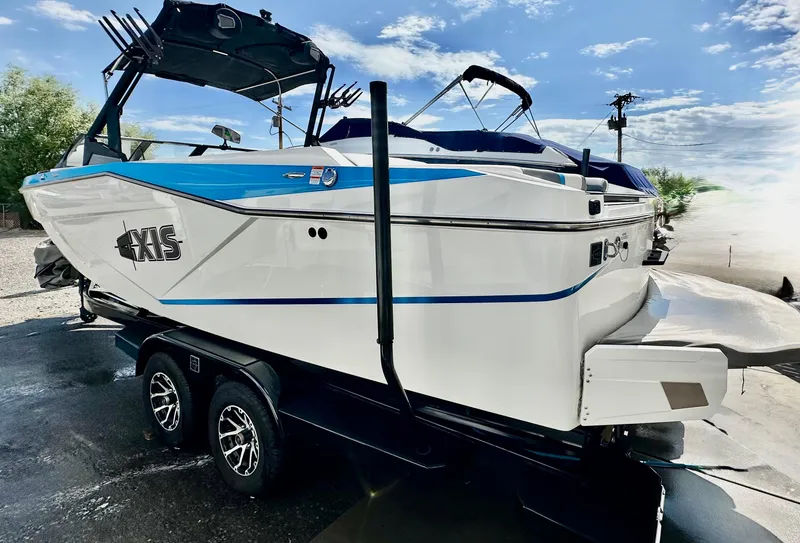 Slide: The Image of 2024 Axis T250 boat on trailer, featuring sleek design and vibrant blue accents. - 2