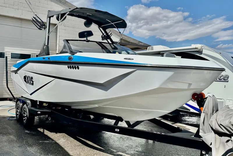 Slide: The Image of 2024 Axis T250 boat on trailer, sleek design, blue and white color scheme. - 4