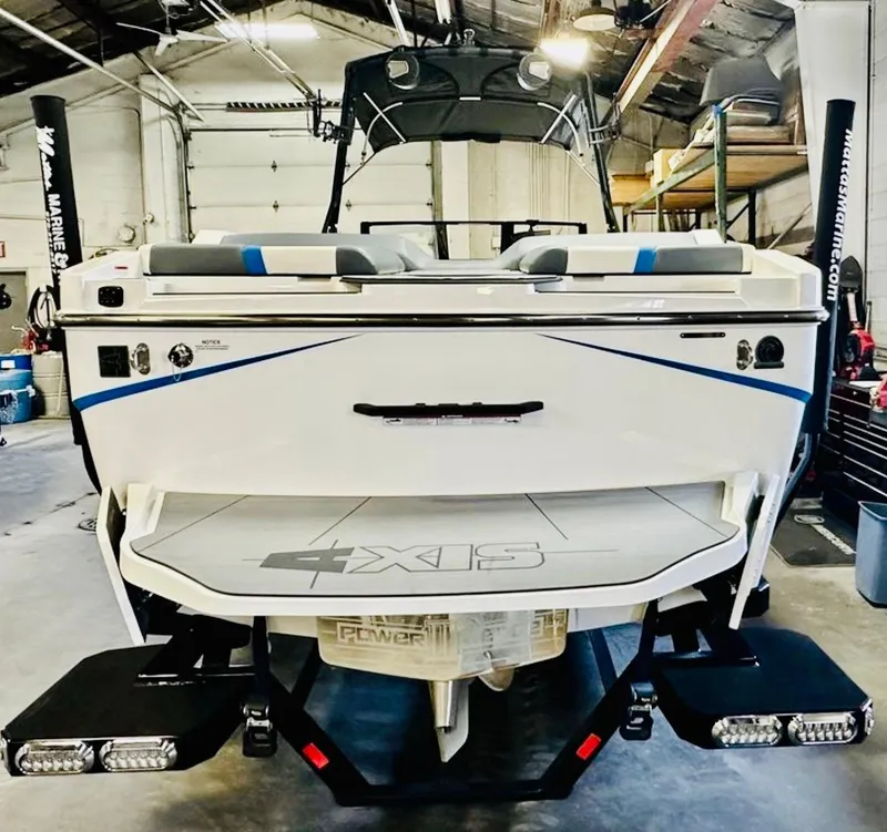 Slide: The Image of 2024 Axis T250 boat on trailer, white with blue accents, parked outdoors. - 5