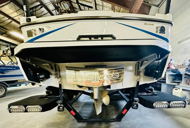 Slide: The Image of 2024 Axis T250 boat in a garage, rear view with swim platform and seating. - 6