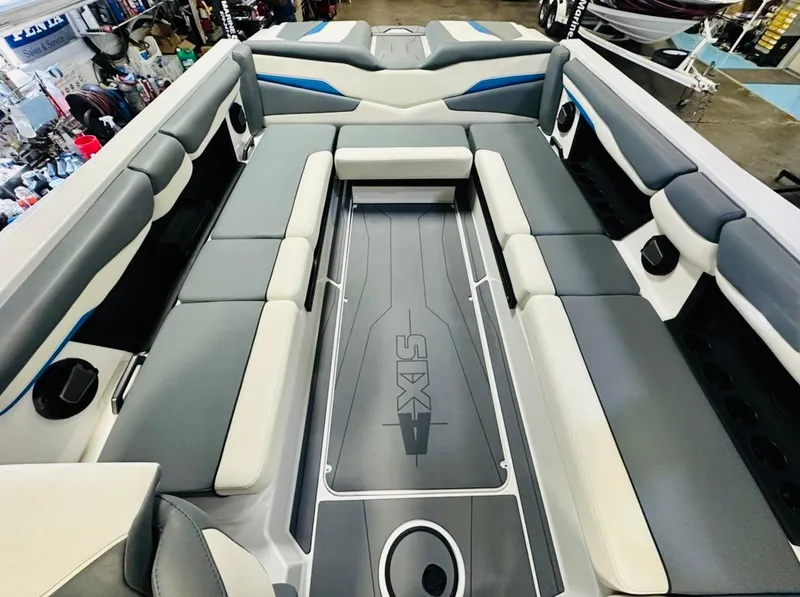 Slide: The Image of 2024 Axis T250 boat interior with spacious seating and modern design in a garage setting. - 8