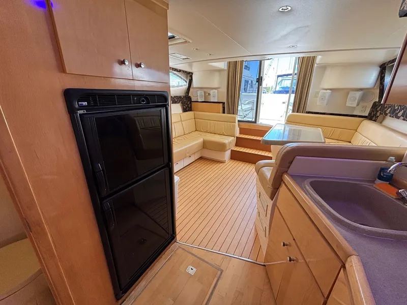 Slide: The Image of Interior of 2001 Carver 350 Mariner yacht with kitchen, seating, and wooden flooring. - 18