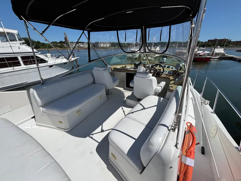 Slide: The Image of 2001 Carver 350 Mariner yacht interior with seating and helm, docked in a marina. - 8