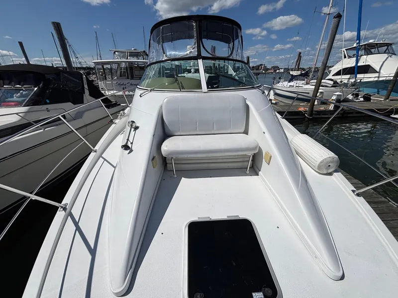 Slide: The Image of 2001 Carver 350 Mariner boat docked, featuring spacious deck and seating under clear skies. - 9
