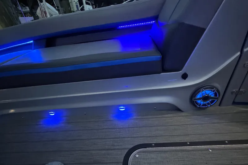Slide: The Image of 2021 Manitou 25 XT SRS boat interior with blue LED lighting and speaker. - 10
