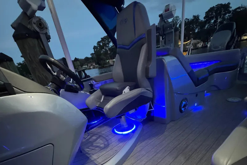 Slide: The Image of 2021 Manitou 25 XT SRS boat interior with illuminated seating and steering area. - 11