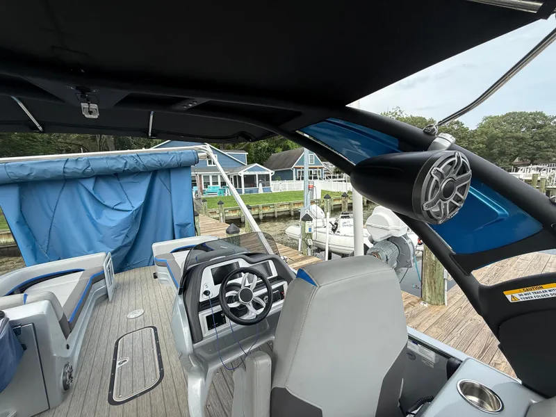 Slide: The Image of 2021 Manitou 25 XT SRS boat interior with steering wheel and speaker system. - 17