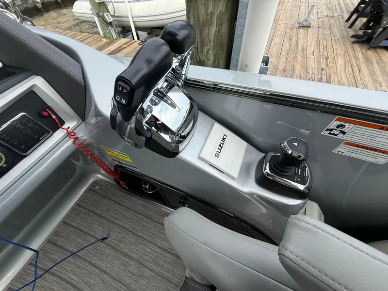 Slide: The Image of Control panel of 2021 Manitou 25 XT SRS boat with Suzuki throttle and joystick. - 4