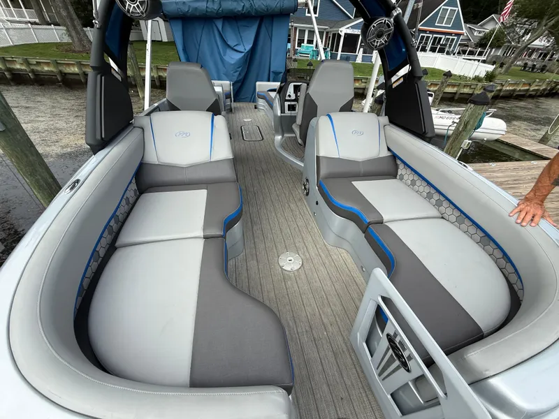 Slide: The Image of 2021 Manitou 25 XT SRS pontoon boat interior with gray and blue seating. - 6