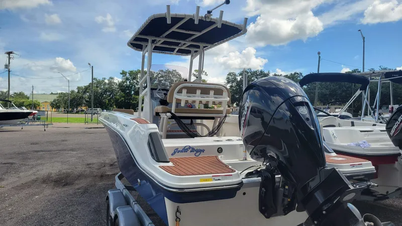 Slide: The Image of 2024 Trophy T20CC boat with Mercury engine, parked outdoors under a blue sky. - 10