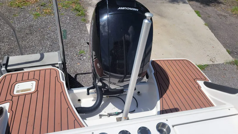 Slide: The Image of 2024 Trophy t20cc boat with Mercury outboard motor, featuring teak-style deck flooring. - 14