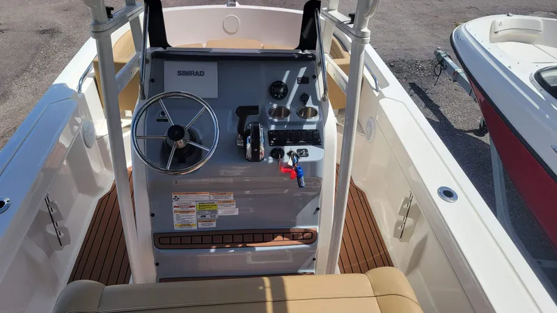 Slide: The Image of 2024 Trophy T20CC boat console with steering wheel, controls, and Simrad display. - 21