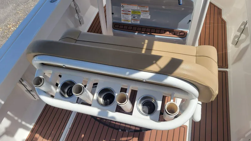 Slide: The Image of 2024 Trophy t20cc boat seat with rod holders and cup holders on teak flooring. - 22