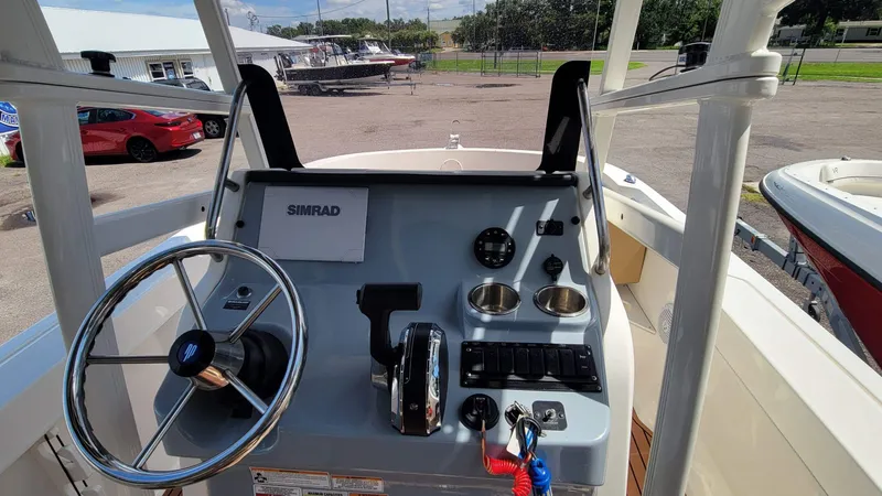 Slide: The Image of 2024 Trophy T20CC boat console with steering wheel, controls, and Simrad display. - 25