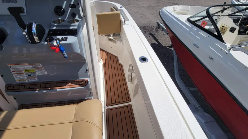 Slide: The Image of Interior view of a 2024 Trophy T20CC boat with tan seating and wood accents. - 32