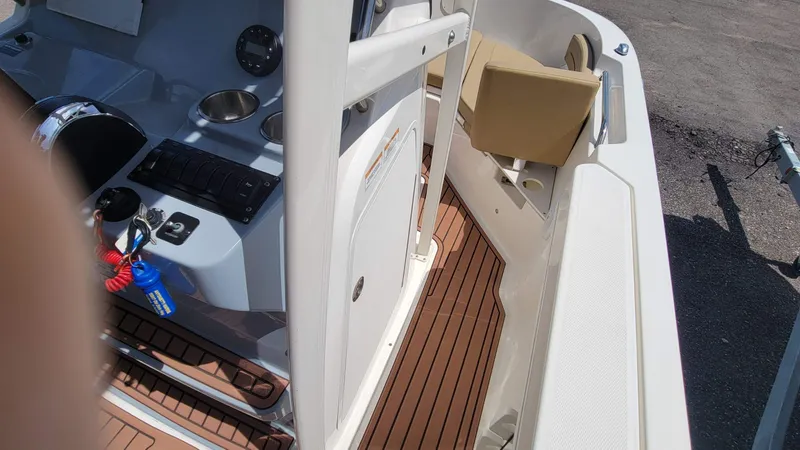 Slide: The Image of 2024 Trophy T20CC boat interior with control panel and seating, featuring wood-style flooring. - 33