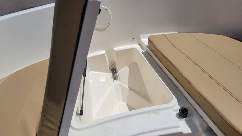 Slide: The Image of 2024 Trophy T20CC boat storage compartment with beige cushioned seating. - 41