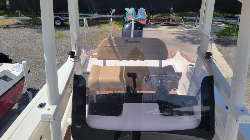 Slide: The Image of 2024 Trophy T20CC boat interior with steering wheel and seating, parked outdoors. - 46