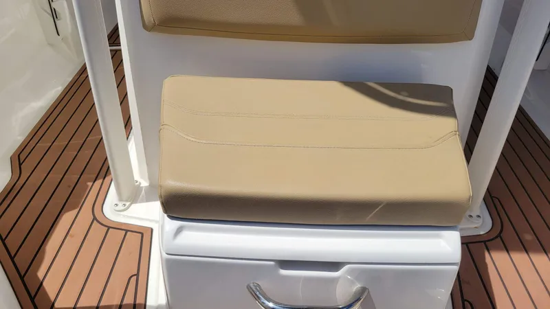 Slide: The Image of 2024 Trophy T20CC boat seat with tan cushion and wood-patterned flooring. - 47