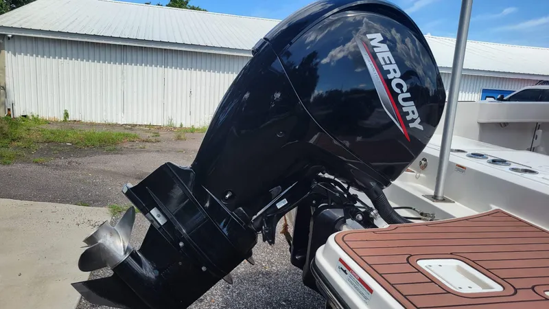 Slide: The Image of 2024 Trophy T20CC boat with Mercury outboard motor, docked near a white building. - 8