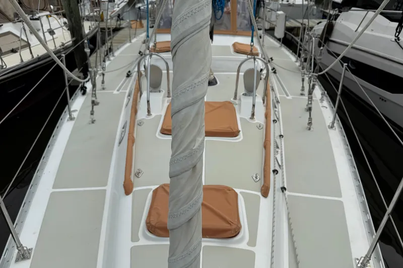 Slide: The Image of 2008 Hylas 46 sailboat deck with tan covers and rigging in marina. - 13