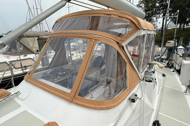 Slide: The Image of 2008 Hylas 46 sailboat with tan canvas cockpit enclosure at marina. - 14