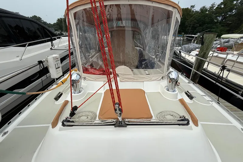 Slide: The Image of 2008 Hylas 46 sailboat deck with red ropes and protective canopy in marina. - 16