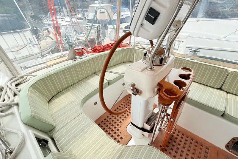 Slide: The Image of Cockpit of 2008 Hylas 46 sailboat with striped seating and wooden steering wheel. - 20