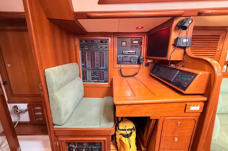 Slide: The Image of Navigation station of 2008 Hylas 46 yacht with control panels and seating. - 24
