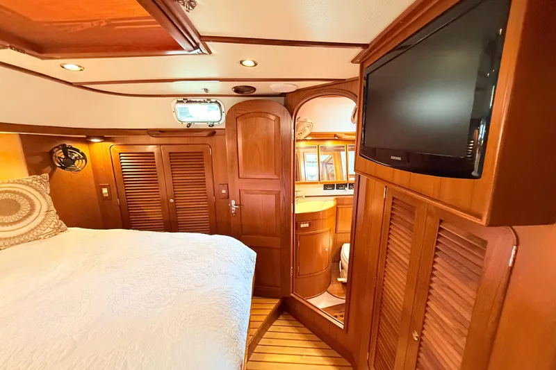 Slide: The Image of Luxurious 2008 Hylas 46 yacht interior with wood paneling, cozy bed, and mounted TV. - 29