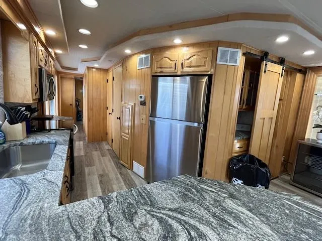 Slide: The Image of Interior of 2001 Horizon 16 x 70 Houseboat with modern kitchen and wood paneling. - 11
